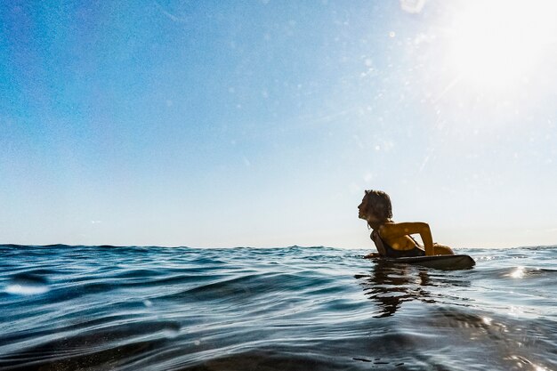 Mujer con tabla de surf en agua