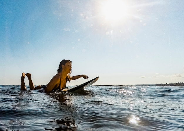 Mujer con tabla de surf en agua