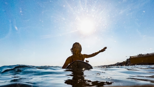 Mujer con tabla de surf en agua