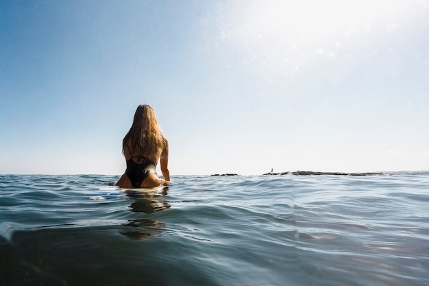 Foto gratuita mujer con tabla de surf en agua