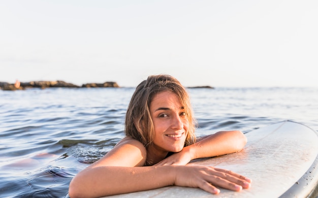 Mujer con tabla de surf en agua