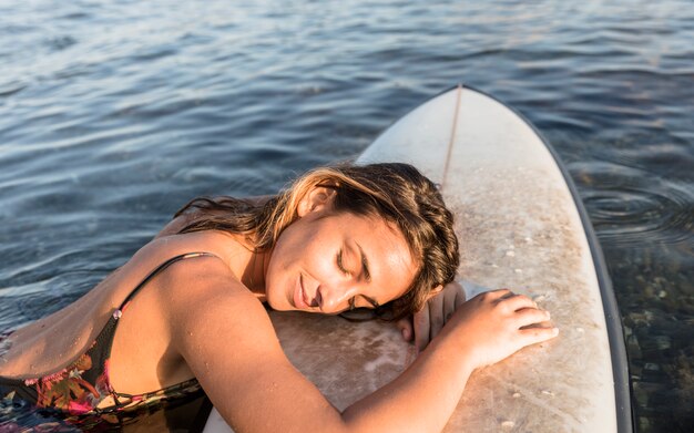 Mujer con tabla de surf en agua