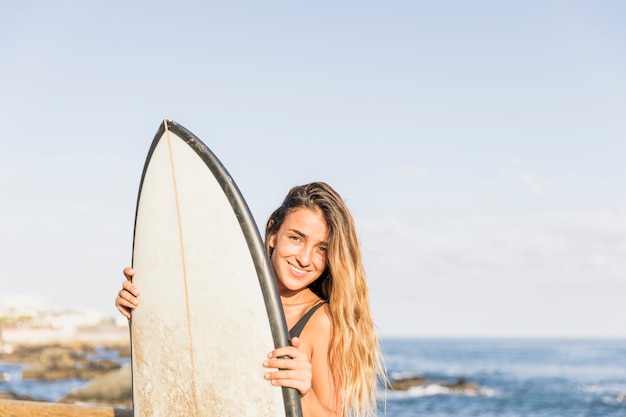 Foto gratuita mujer con tabla de surf en la playa