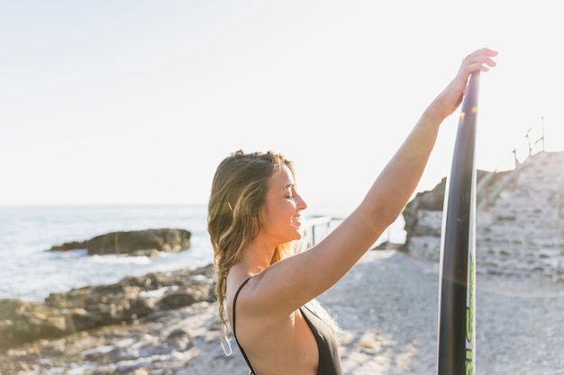 Foto gratuita mujer con tabla de surf en la playa