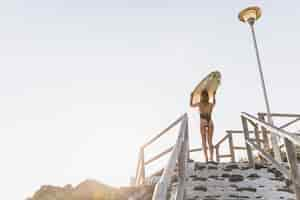 Foto gratuita mujer con tabla de surf en la playa