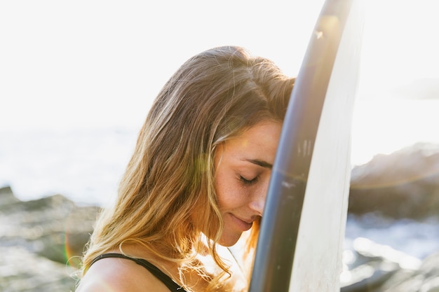 Mujer con tabla de surf en la playa