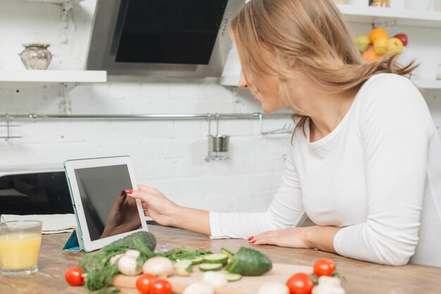 Mujer con tableta en cocina