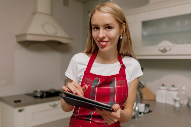 mujer con tableta en cocina