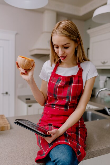 mujer con tableta en cocina