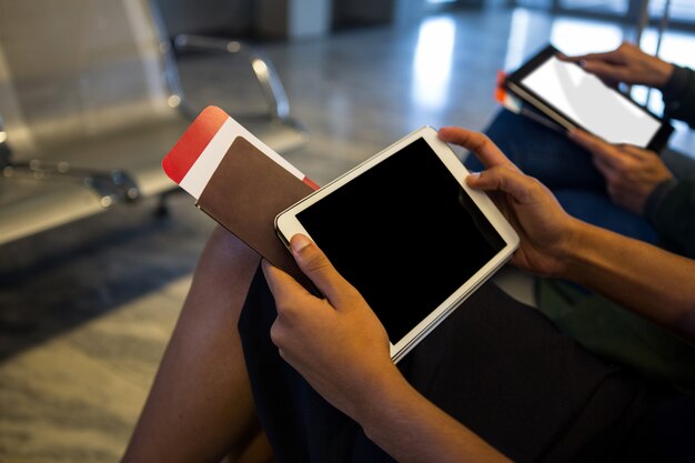 Mujer con tableta digital en la sala de espera en el aeropuerto