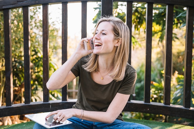 Foto gratuita mujer con tableta hablando por teléfono