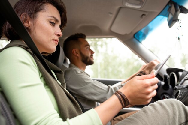 Mujer con tableta mientras su novio está conduciendo