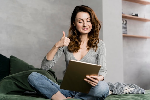 Mujer con tableta mostrando aprobación