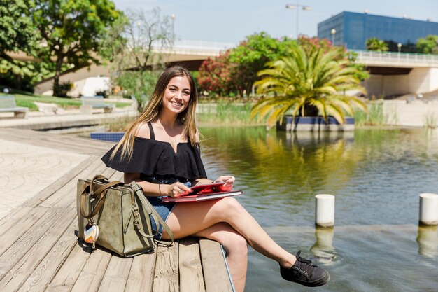 Mujer con tableta en parque con lago