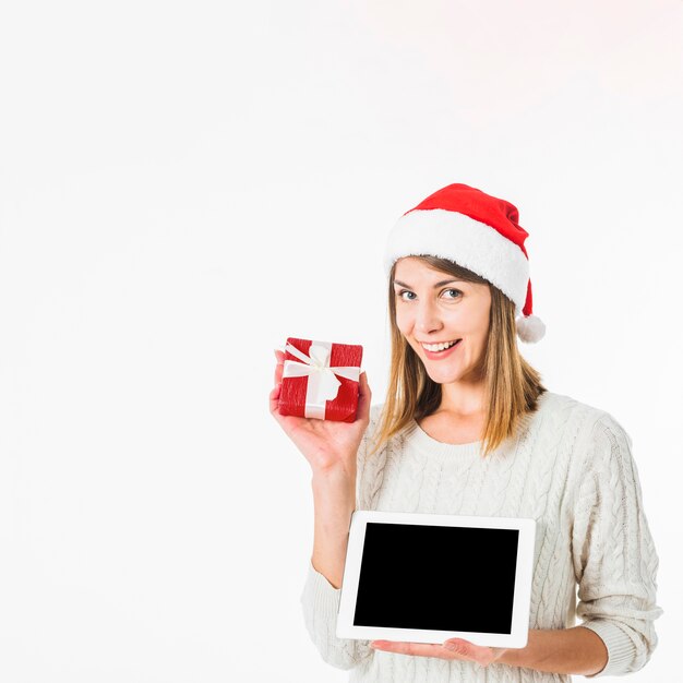 Mujer con tableta y pequeña caja de regalo.