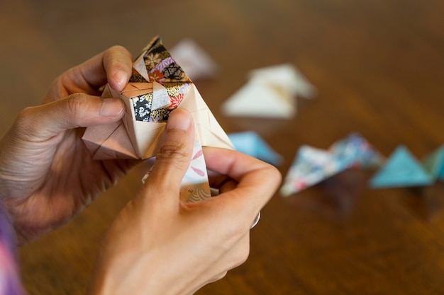 Mujer talentosa haciendo origami con papel japonés