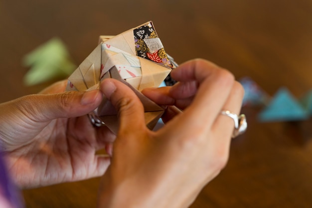 Mujer talentosa haciendo origami con papel japonés