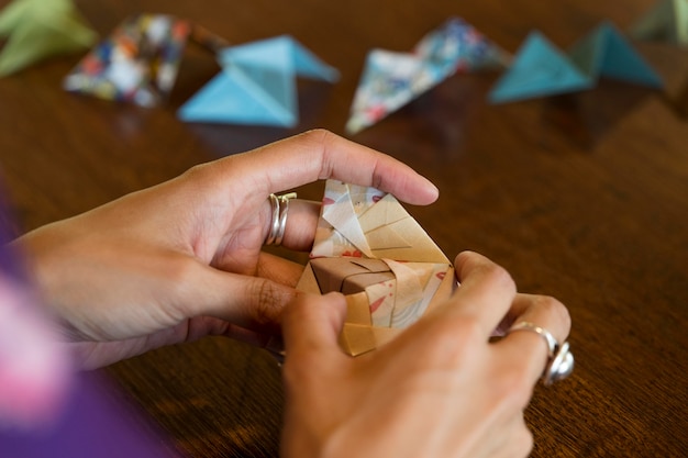 Mujer talentosa haciendo origami con papel japonés