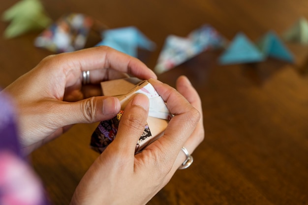 Mujer talentosa haciendo origami con papel japonés