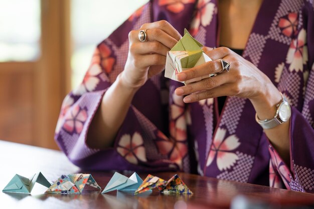 Mujer talentosa haciendo origami con papel japonés