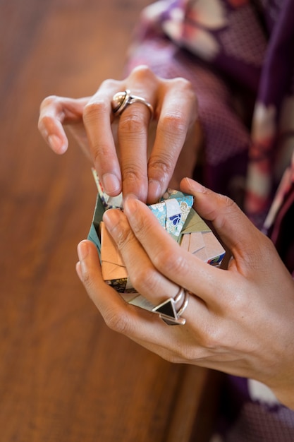 Mujer talentosa haciendo origami con papel japonés