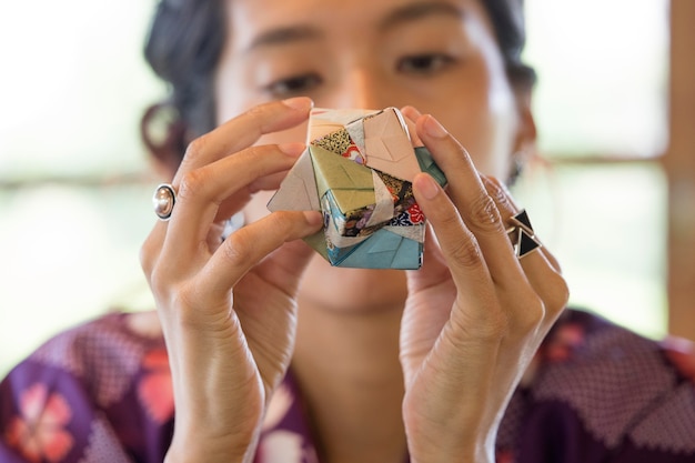 Mujer talentosa haciendo origami con papel japonés