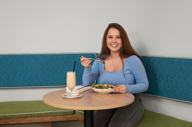 Foto gratuita mujer de talla grande comiendo sola en un restaurante