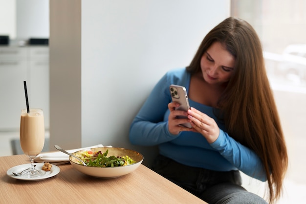 Foto gratuita mujer de talla grande comiendo sola en un restaurante