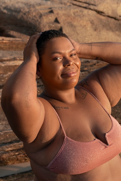 Una mujer de talla mediana posando en la orilla del mar