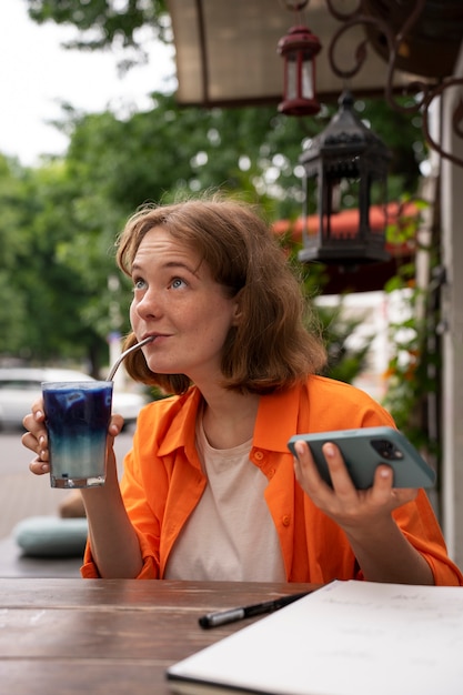 Una mujer de tamaño medio disfrutando de un matcha azul.