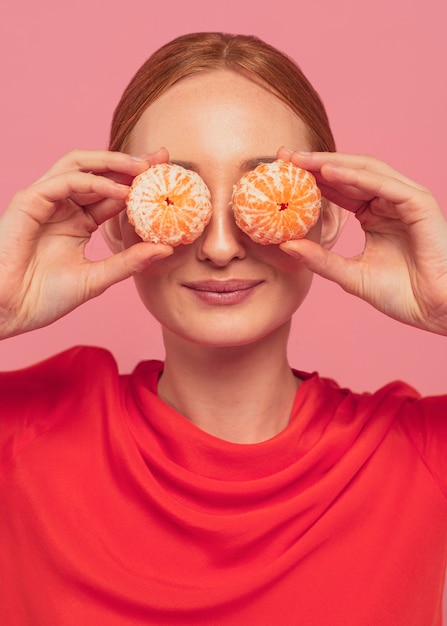 Foto gratuita mujer tapándose los ojos con naranjas