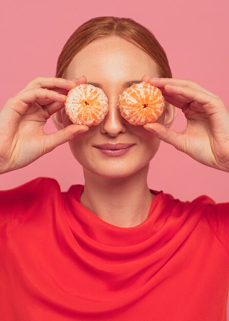 Mujer tapándose los ojos con naranjas