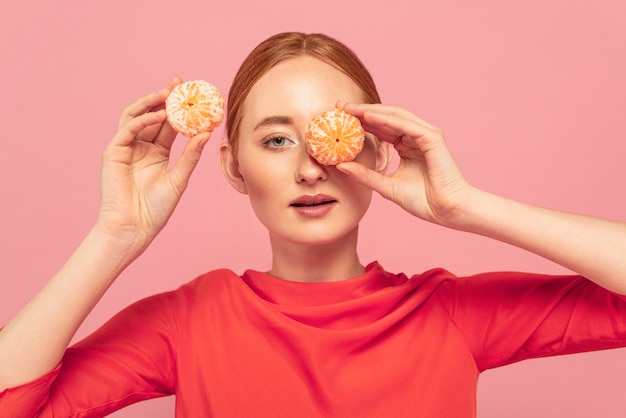 Foto gratuita mujer tapándose los ojos con naranjas