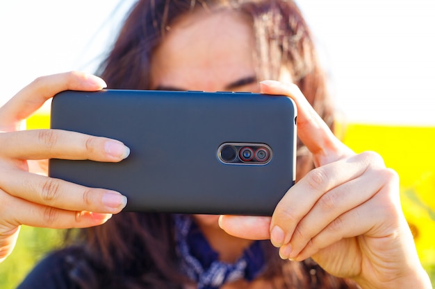 Foto gratuita una mujer por la tarde dispara por teléfono en el campo.