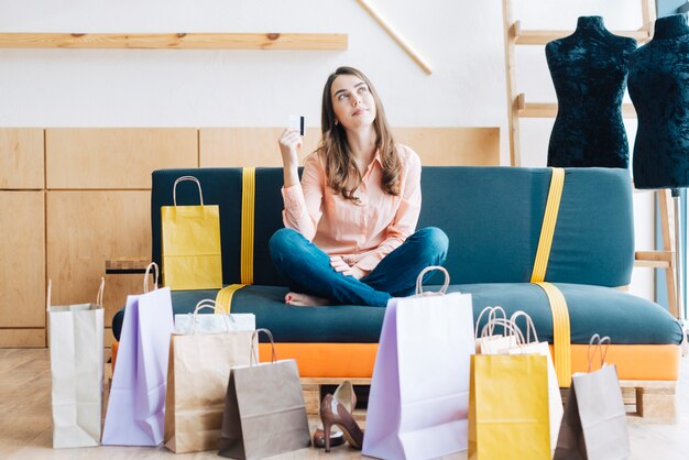 Mujer con tarjeta de crédito en el sofá