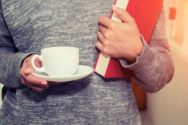 Mujer con una taza y un libro