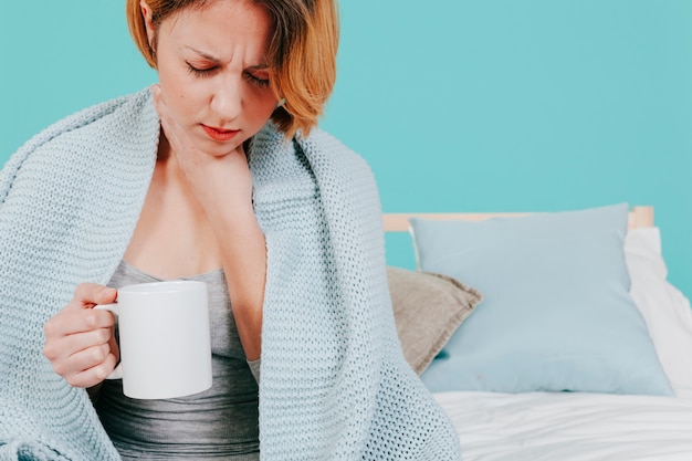 Mujer con taza sintiéndose enfermo