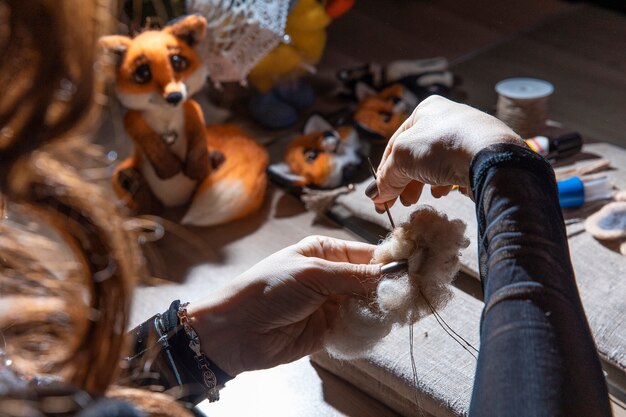 Mujer tejiendo peluches en el atelier