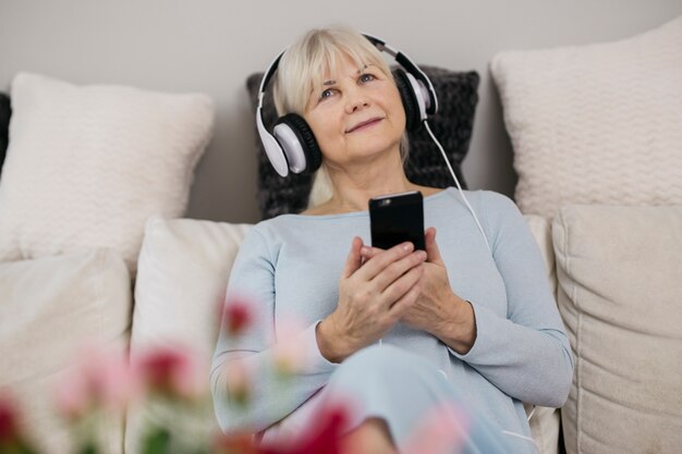 Mujer con teléfono inteligente escuchando música