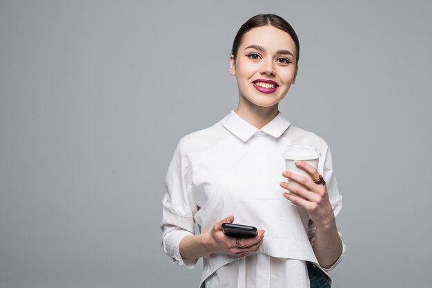 Mujer con teléfono móvil y café en blanco