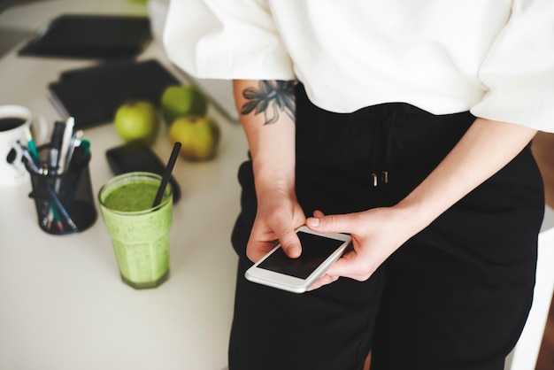 Foto gratuita mujer con teléfono móvil en la oficina en casa