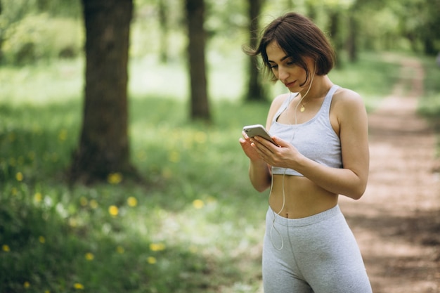 Mujer con teléfono en ropa deportiva