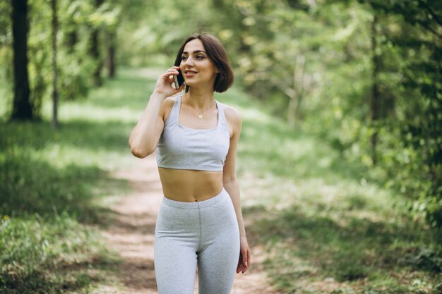 Mujer con teléfono en ropa deportiva