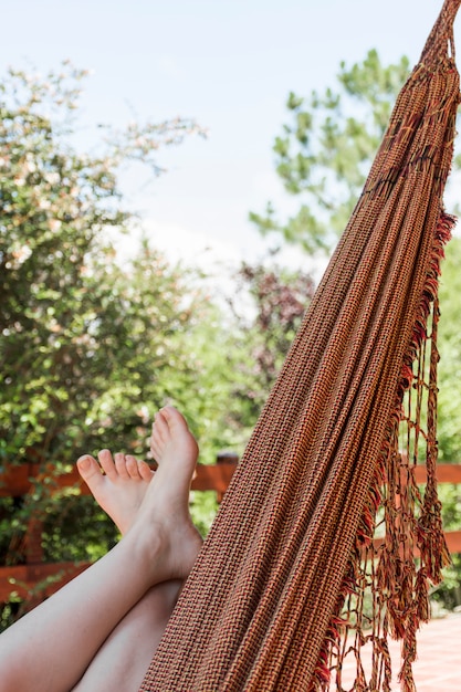 Foto gratuita mujer tendida en hamaca en terraza en verano