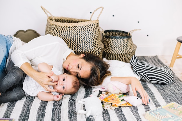 Foto gratuita mujer tendida en un trapo a rayas con bebé