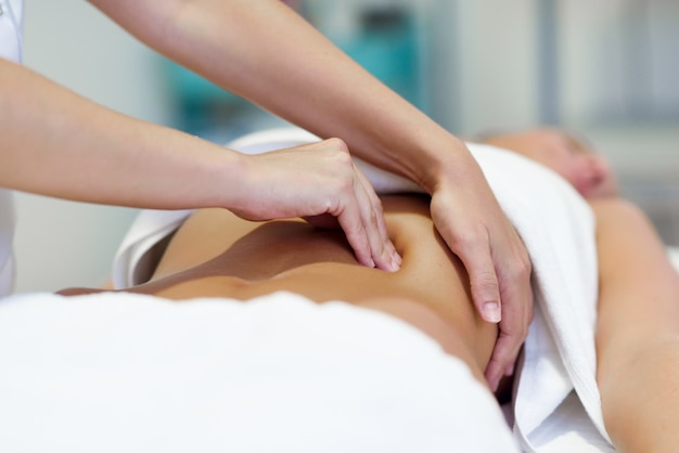 Mujer, teniendo, abdomen, masaje, profesional, osteopatía, terapeuta