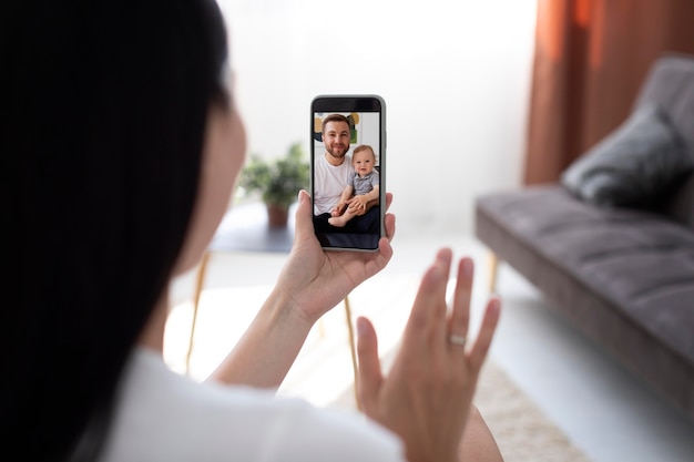 Foto gratuita mujer teniendo una videollamada con su familia