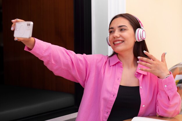 Mujer teniendo una videollamada en un teléfono inteligente mientras está en la ciudad