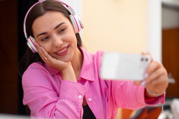 Mujer teniendo una videollamada en un teléfono inteligente mientras está en la ciudad