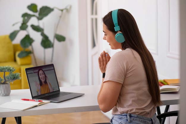 Mujer teniendo una videollamada usando un dispositivo portátil desde casa